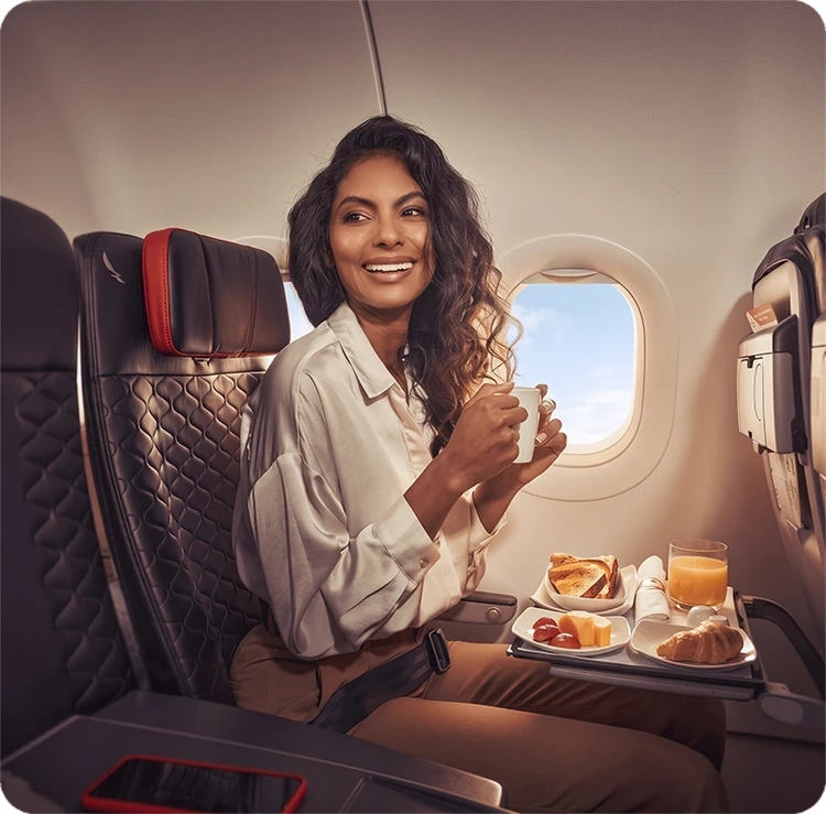 Mujer en avión disfrutando del menú abordo