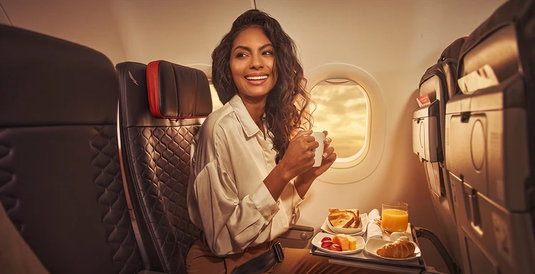 Mujer en avión disfrutando del menú abordo