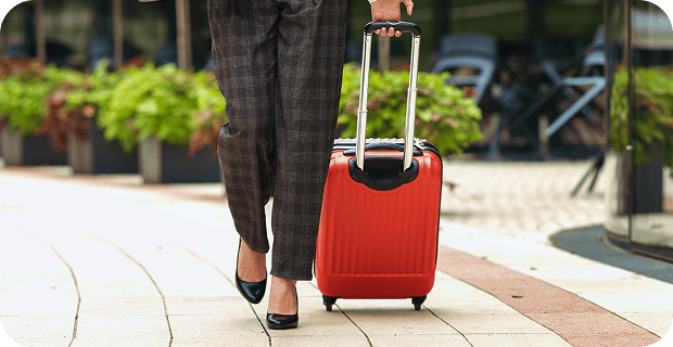 mujer caminando con maleta carry on