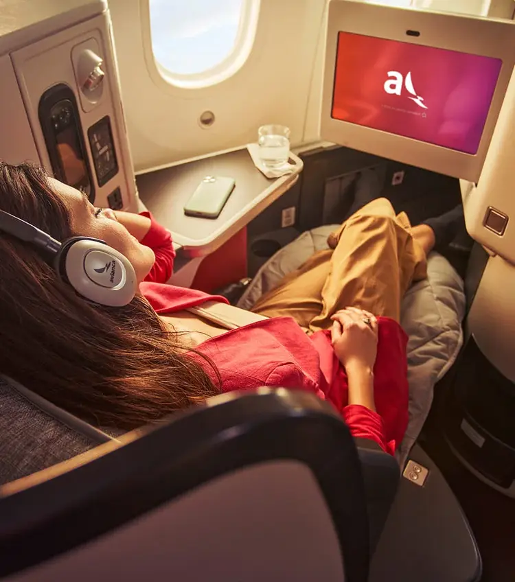 mujer en avión disfrutando del entretenimiento a bordo