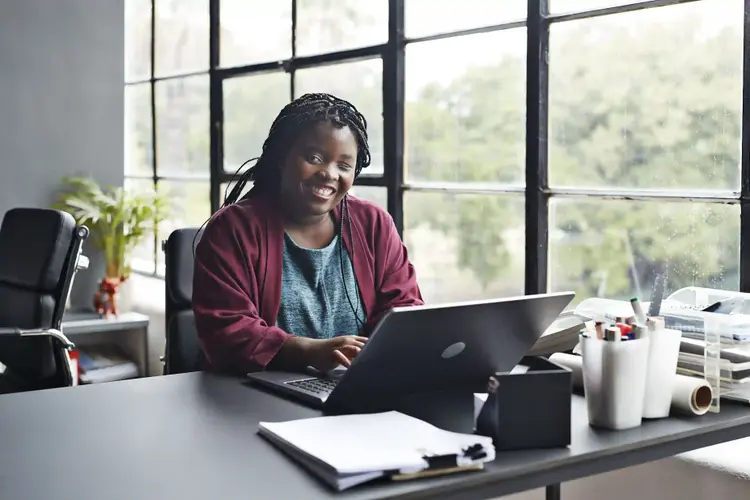 femme assise à un bureau devant un ordinateur